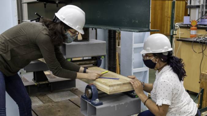 Two students working in hard hats