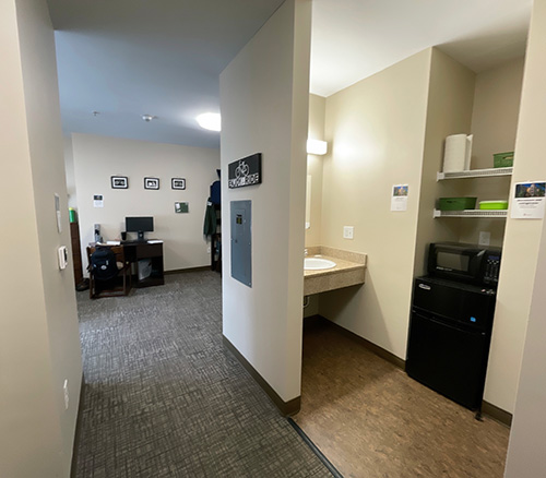 Centennial hall Triples room. A microwave, fridge and wash basin is shown in the room