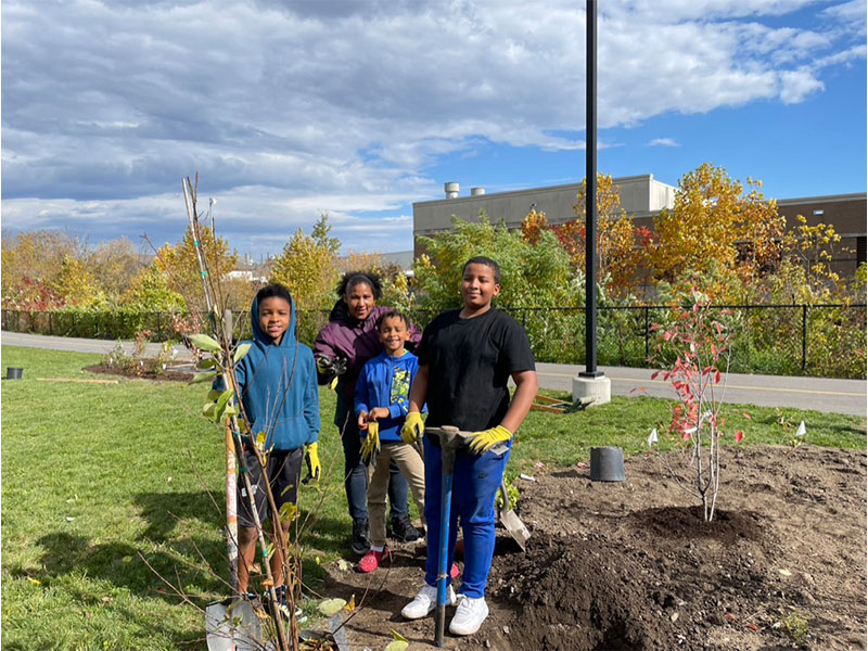 3 kids holding gardening equipment at oxford planting