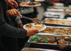 Serving food from catering pans.