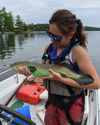 Anna on a boat holding a fish