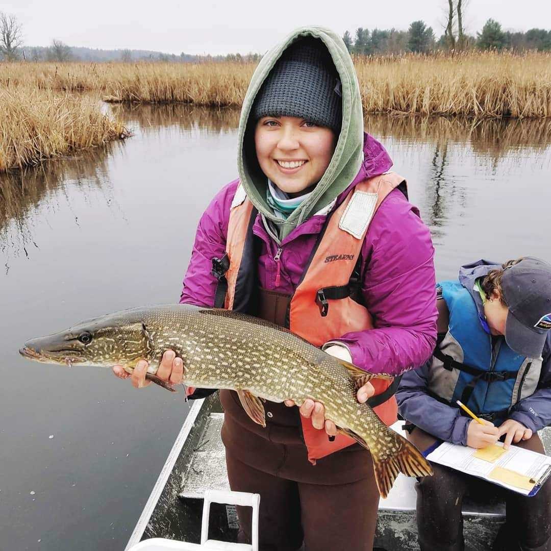 Katelyn holding a fish on a boat