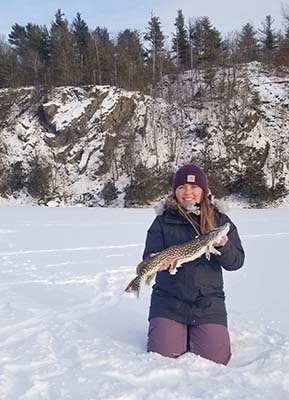 Katlyn barhite holding a fish in the snow