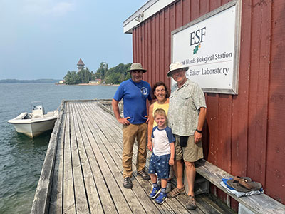 Nels, Debbie, and their grandson (Logan) on a visit to TIBS get a group photo with John Farrell