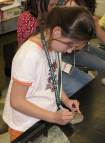 a girl writing on a petri dish