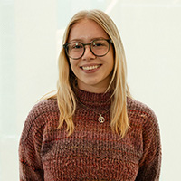 Margaret Ryan wearing glasses and a brown sweater