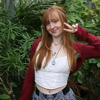 Mariel wearing a white top and red sweater